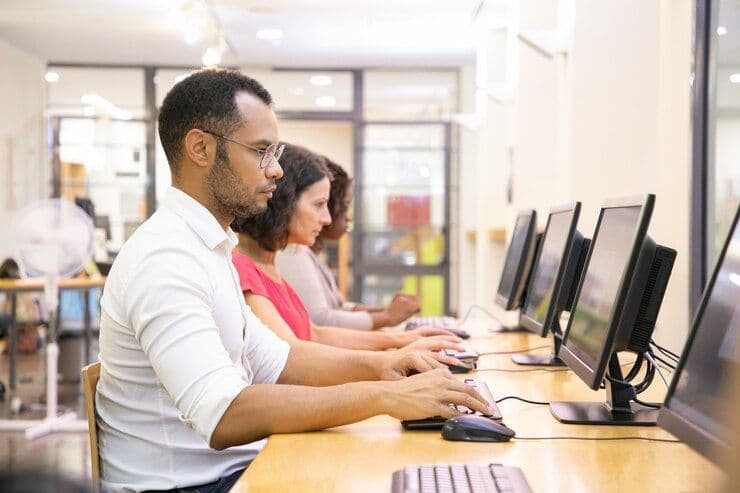 tudents coding or working in a modern computer lab with digital screens.jpg